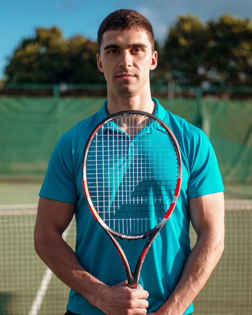 athletic-male-tennis-player-plays-on-outdoor-court-PYEVUKM.jpg